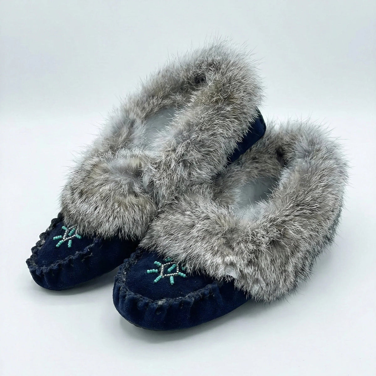Pair of slippers with fur trim on a white background