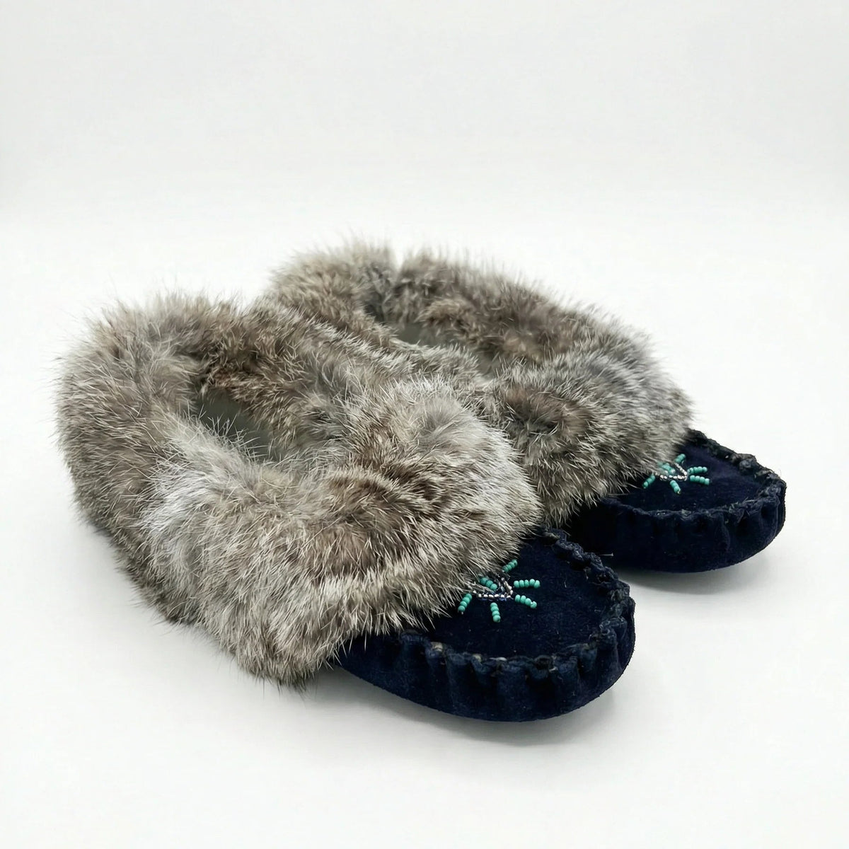 Pair of slippers with fur trim on a white background