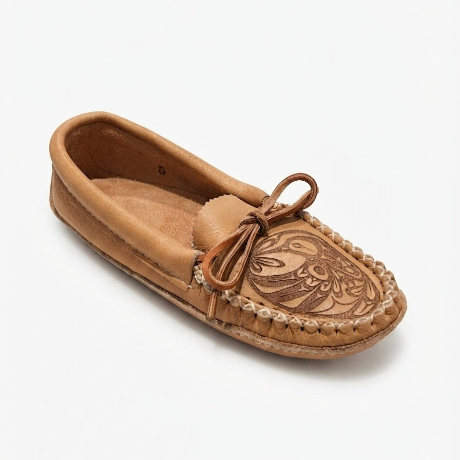 A tan leather moccasin loafer with hand-tooled floral detailing on the vamp and a matching leather tie, shown on a light gray background.