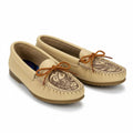 Pair of beige moccasin shoes with brown decorative sole on a white background